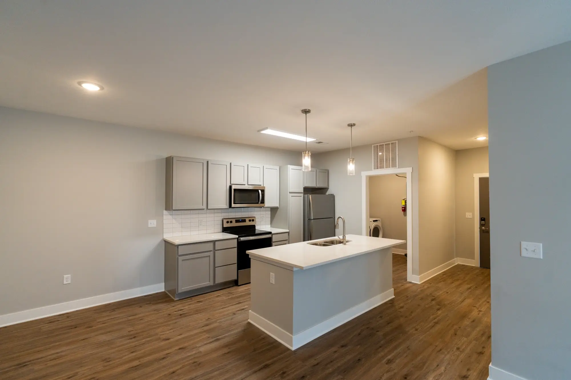 New apartment construction kitchen with white cabinetry, stainless steel appliances, and quartz counters by AY Remodeling and Restoration