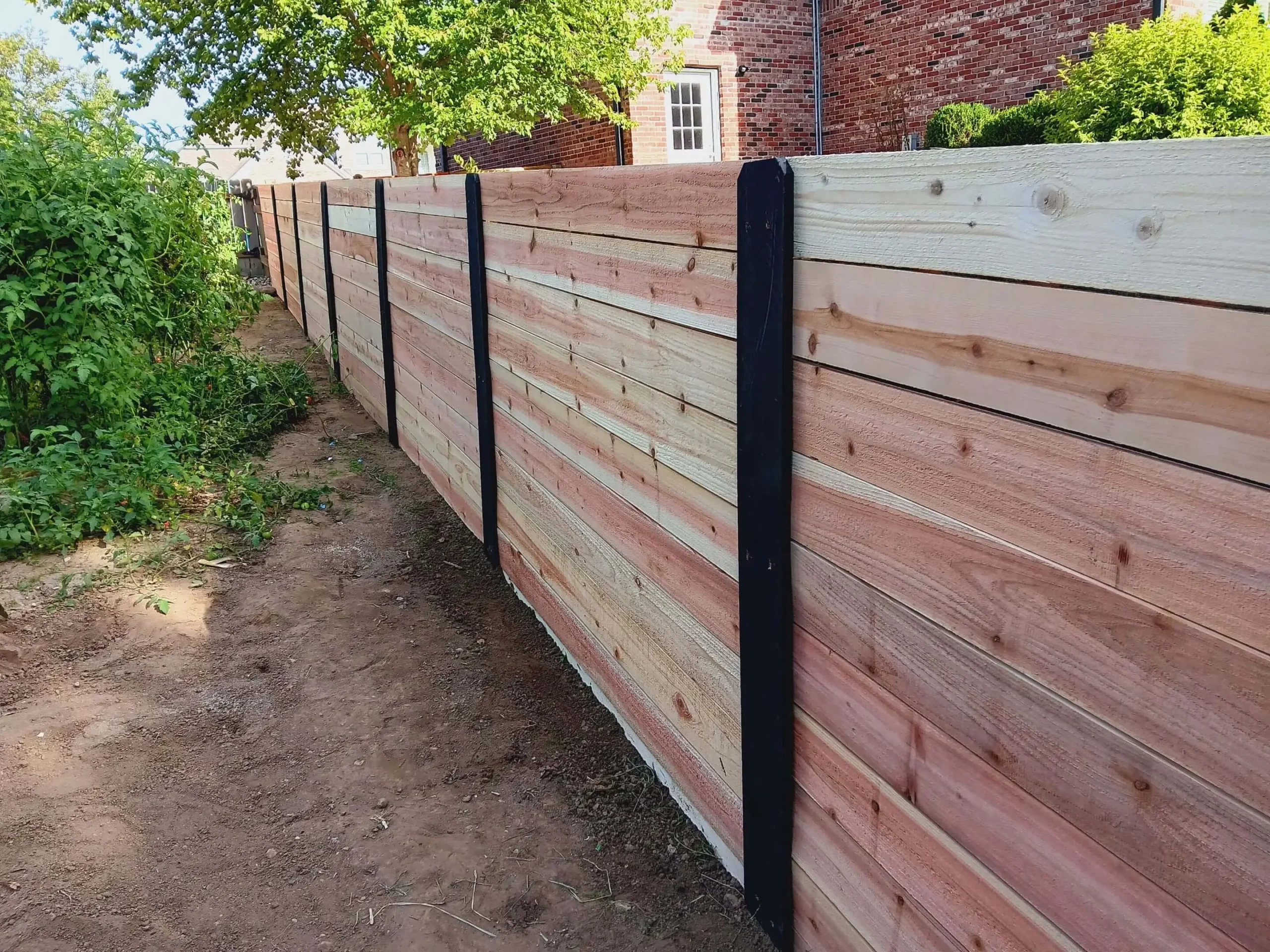Horizontal wood privacy fence with black metal posts installed by AY Remodeling in Carmel, Indiana.